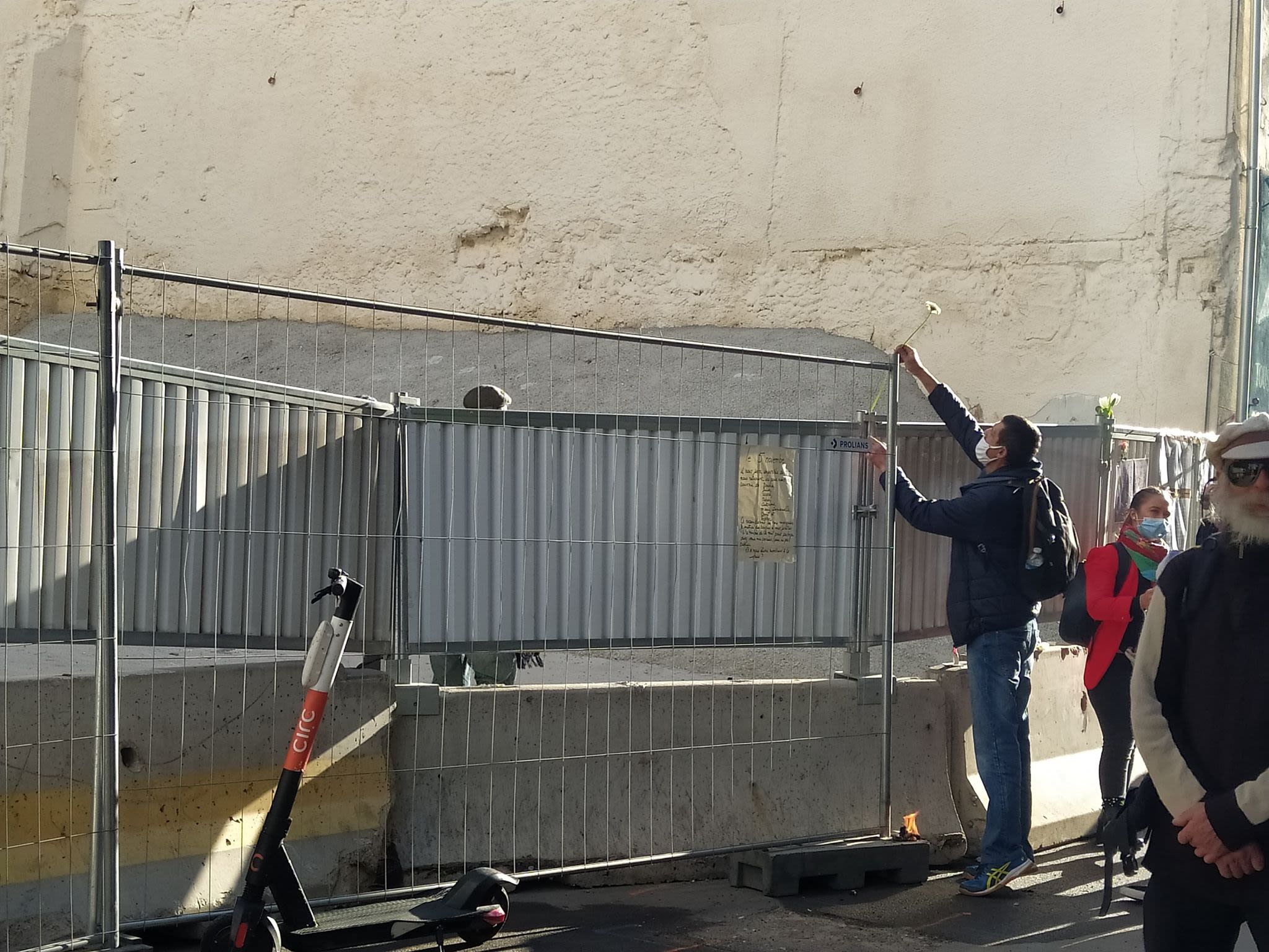 Un homme dépose une fleur sur les barrières de chantier devant les immeubles absents, 5 novembre 2020 - Julie Malfoy